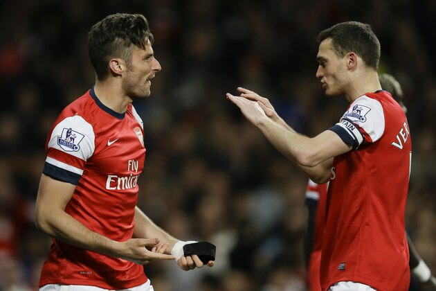 Arsenal's Olivier Giroud, left, celebrates with teammate Thomas Vermaelen, right, after he scores a goal past West Ham's goalkeeper Adrian during the English Premier League soccer match between Arsenal and West Ham United at the Emirates stadium in London, Tuesday, April 15, 2014. (AP Photo/Kirsty Wigglesworth)