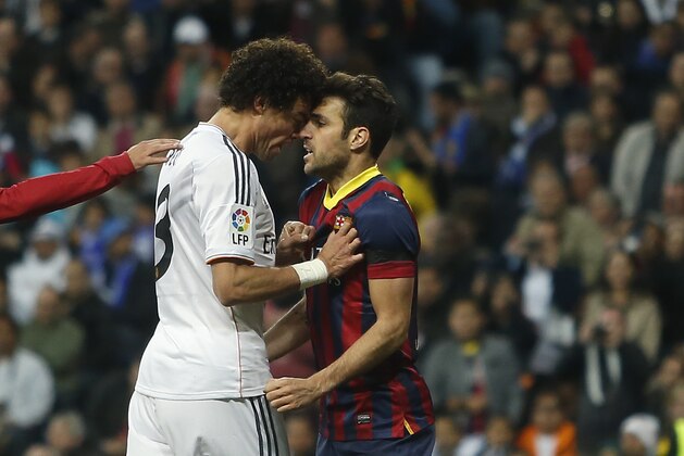Real's Pepe, left, reacts with Barcelona's Cesc Fabregas, right, as Fabregas celebrated Lionel Messi's goal, during a Spanish La Liga soccer match between Real Madrid and FC Barcelona at the Santiago Bernabeu  stadium in Madrid, Spain, Sunday, March 23, 2014. (AP Photo/Andres Kudacki)