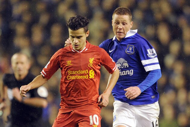 Liverpool's Philippe Coutinho, left, and Everton's James McCarthy battle for the ball during their English Premier League soccer match at Anfield in Liverpool, England, Tuesday Jan. 28, 2014. (AP Photo/Clint Hughes)