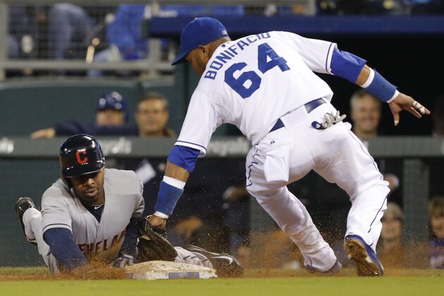 Cleveland Indians' Michael Bourn, left, gets back to first base before the tag of Kansas City Royals second baseman Emilio Bonifacio (64) during the fifth inning of a baseball game at Kauffman Stadium in Kansas City, Mo., Monday, Sept. 16, 2013. Bourn singled on a bunt to Royals third baseman Jamey Carroll who overthrew the first baseman on the play. (AP Photo/Orlin Wagner)
