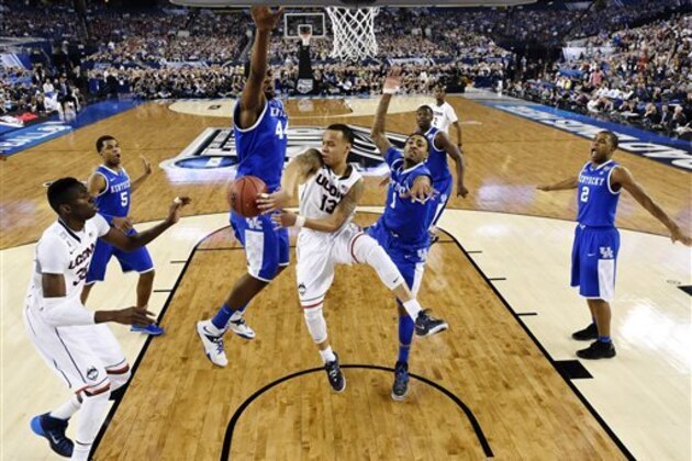 Connecticut guard Shabazz Napier (13) passes around Kentucky center Dakari Johnson (44) to center Amida Brimah (35) as guard James Young (1) helps during the first half of the NCAA Final Four tournament college basketball championship game Monday, April 7, 2014, in Arlington, Texas. (AP Photo/Chris Steppig, pool)
