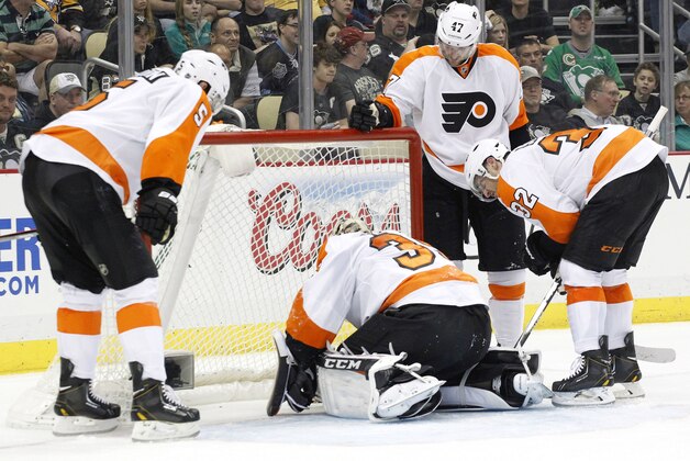 Apr 12, 2014; Pittsburgh, PA, USA; Philadelphia Flyers goalie Steve Mason (35) rest on the ice in front of Flyers defenseman Braydon Coburn (5) and defenseman Andrew MacDonald (47) and defenseman Mark Streit (32) against the Pittsburgh Penguins during the second period at the CONSOL Energy Center.  The Flyers won 4-3 in overtime. Mandatory Credit: Charles LeClaire-USA TODAY Sports