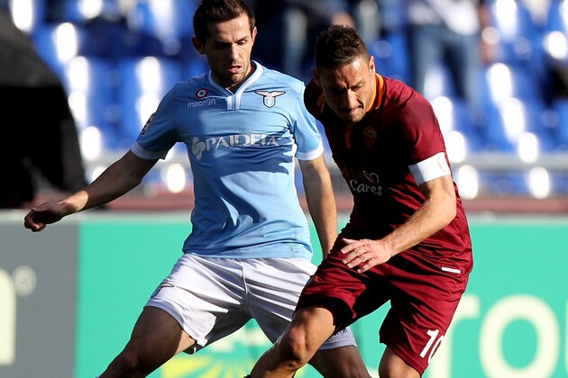 Roma forward Francesco Totti walks past the project for the new Roma soccer stadium, at Rome's Capitol Hill, Wednesday March 26, 2014. Three-time Serie A champion Roma has revealed plans to build a new privately financed stadium on the outskirts of the Italian capital. Labeled