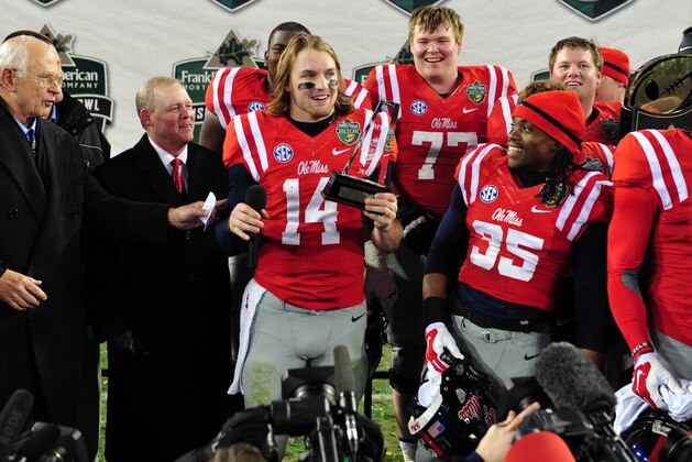 Dec 30, 2013; Nashville, TN, USA; Mississippi Rebels quarterback Bo Wallace (14) accepts the MVP trophy after a game against the Georgia Tech Yellow Jackets at LP Field. The Rebels beat the Yellow Jackets 25-17. Mandatory Credit: Don McPeak-USA TODAY Sports