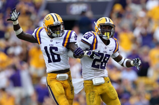 Oct 12, 2013; Baton Rouge, LA, USA; LSU Tigers defensive back Tre'Davious White (16) and cornerback Jalen Mills (28)  Mills' sack of Florida Gators quarterback Tyler Murphy (3) in the fourth quarter of their game at Tiger Stadium. Mandatory Credit: Chuck Cook-USA TODAY Sports