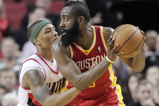 Houston Rockets guard James Harden, right, looks for a move to the basket as Portland Trail Blazers guard Damian Lillard defends during the second half of an NBA basketball game in Portland, Ore., Friday, April 5, 2013.  Harden scored 33 points and pulled in 7 rebounds as the Rockets won 116-98. (AP Photo/Don Ryan)