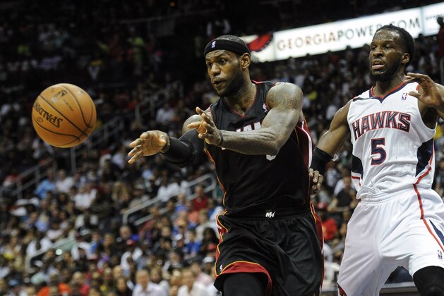 Miami Heat forward LeBron James (6) passes as Atlanta Hawks forward DeMarre Carroll (5) defends during an NBA basketball game, Saturday, April 12, 2014, in Atlanta. Atlanta won 98-85. (AP Photo/John Amis)