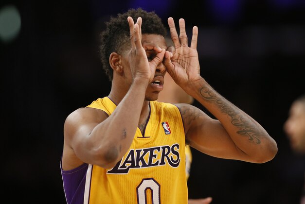 Los Angeles Lakers forward Nick Young puts his fingers around his eyes as he celebrates a three-pointer against the Portland Trail Blazers during the second half of an NBA basketball game in Los Angeles, Tuesday, April 1, 2014. (AP Photo/Danny Moloshok)