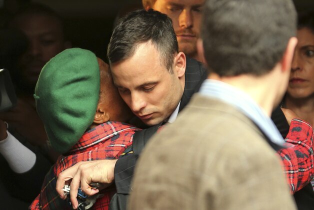 Oscar Pistorius, center, shares a hug with an unidentified woman as he leaves the high court in Pretoria, South Africa, Wednesday, April 16, 2014. Pistorius is charged with murder for the shooting death of his girlfriend, Reeva Steenkamp, on Valentines Day in 2013. (AP Photo/Themba Hadebe)