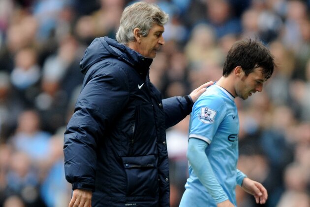 Manchester City manager Manuel Pellegrini, left, pats David Silva on the back after he is substituted  during the English Premier League soccer match between Manchester City and Southampton at The Etihad Stadium, Manchester, England, Saturday, April  5, 2014.  (AP Photo/Rui Vieira)