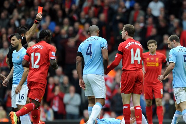 Liverpool's Jordan Henderson third right, is shown a red card by referee Mark Clattenburg left, after he fouls Manchester City's Samir Nasri during their English Premier League soccer match at Anfield in Liverpool, England, Sunday April. 13, 2014. (AP Photo/Clint Hughes)