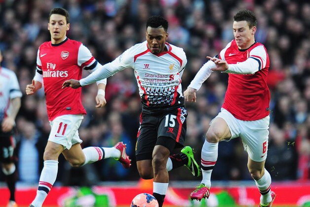 LONDON, ENGLAND - FEBRUARY 16:  Daniel Sturridge (C) of Liverpool holds off Mesut Ozil (L), Laurent Koscielny (R) of Arsenal during the FA Cup Fifth Round match between Arsenal and Liverpool at the Emirates Stadium on February 16, 2014 in London, England.  (Photo by Shaun Botterill/Getty Images)