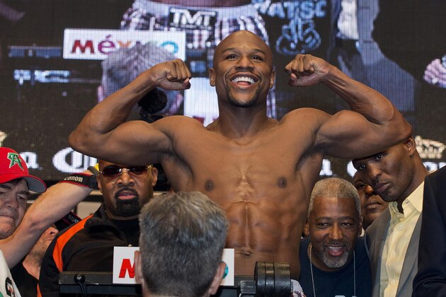 Floyd Mayweather Jr. poses for photos on the scale during the weigh-in for his Saturday boxing match against Canelo Alvarez, Friday, Sept. 13, 2013, in Las Vegas. (AP Photo/Julie Jacobson)