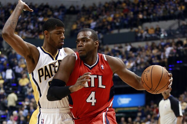 Atlanta Hawks forward Paul Millsap (4) drives around Indiana Pacers forward Paul George during the first half of an NBA basketball game in Indianapolis, Tuesday, Feb. 18, 2014. (AP Photo/R Brent Smith)