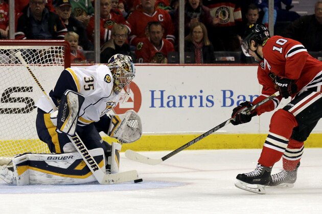 Nashville Predators goalie Pekka Rinne (35) blocks a shot by Chicago Blackhawks' Patrick Sharp (10) during the second period of an NHL hockey game in Chicago, Friday, March 14, 2014. (AP Photo/Nam Y. Huh)