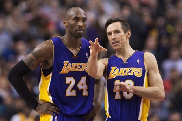 Los Angeles Lakers guards Kobe Bryant, right, and Steve Nash, right, talk during a time-out while playing against the Toronto Raptors during first half NBA basketball action in Toronto on Sunday Jan. 20, 2013. (AP Photo/THE CANADIAN PRESS,Nathan Denette)
