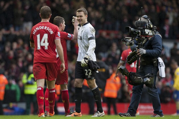 Liverpool's goalkeeper Simon Mignolet, centre, is filmed by a television camera as he shakes hands with teammates after the side's 5-1 win against Arsenal in their English Premier League soccer match at Anfield Stadium, Liverpool, England, Saturday Feb. 8, 2014. (AP Photo/Jon Super)
