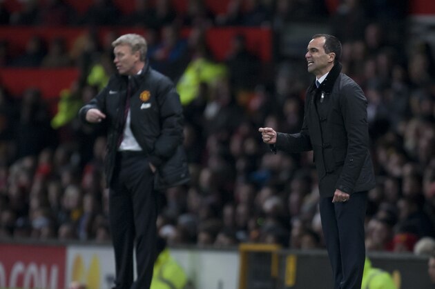 Everton's manager Roberto Martinez, right, issues instructions as he stands alongside Manchester United manager David Moyes during their English Premier League soccer match at Old Trafford Stadium, Manchester, England, Wednesday Dec. 4, 2013. (AP Photo/Jon Super)