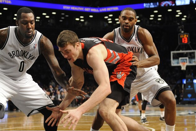 Brooklyn Nets' Andray Blatche (0) and Alan Anderson (6) scramble for a lose ball with Toronto Raptors' Tyler Hansbrough (50) during an NBA basketball game on Monday, March 10, 2014 at Barclays Center in New York. (AP Photo/Kathy Kmonicek)