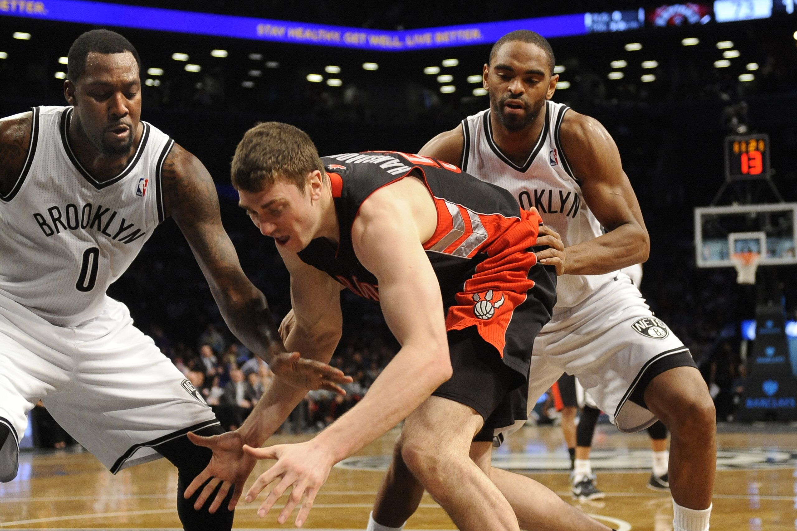 Brooklyn Nets' Andray Blatche (0) and Alan Anderson (6) scramble for a lose ball with Toronto Raptors' Tyler Hansbrough (50) during an NBA basketball game on Monday, March 10, 2014 at Barclays Center in New York. (AP Photo/Kathy Kmonicek)