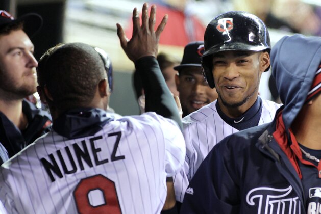 Minnesota Twins' Pedro Florimon is congratulated by teammate Eduardo Nunez after he scored the go-ahead run on a wild pitch by Toronto Blue Jays relief pitcher Sergio Santos during the eighth inning of the second game of a baseball doubleheader, Thursday, April 17, 2014, in Minneapolis. Minnesota won 9-5. AP Photo/Paul Battaglia)
