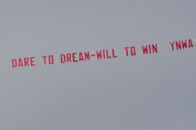 A banner towed by a plane is seen above Liverpool's English Premier League soccer match against Manchester City at Anfield Stadium, Liverpool, England, Sunday April 13, 2014. (AP Photo/Jon Super)