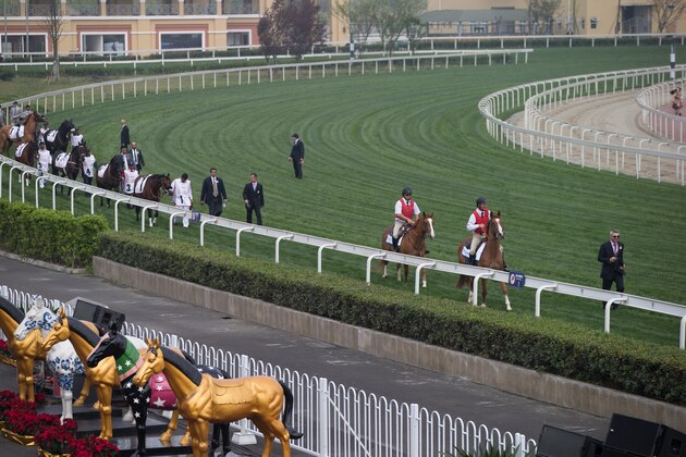 CHENGDU, CHINA - APRIL 06: Patrick Baker leads out the outriders and horses before the first race at the Chengdu Dubai International Cup race meeting at Jinma Racecourse on April 6, 2014 in Chengdu, China.  (Photo by Neville Hopwood/Getty Images)