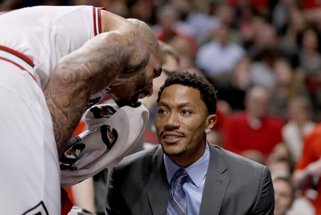 Chicago Bulls forward Carlos Boozer, left, talks to Derrick Rose on the bench during the second half of an NBA basketball game against the Portland Trail Blazers Friday, March 28, 2014, in Chicago. The Trail Blazers won 91-74. (AP Photo/Charles Rex Arbogast)