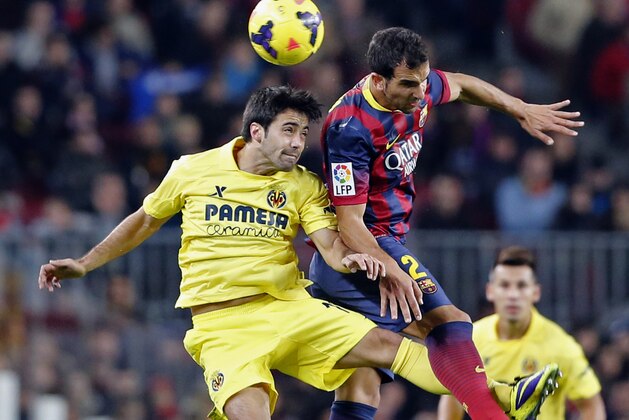 Barcelona's Martin Montoya, right, and Villarreal's Jaume Costa go for a header during a Spanish La Liga soccer match between Barcelona and Villarreal at the Camp Nou stadium in Barcelona, Spain, Saturday, Dec. 14, 2013. (AP Photo/Emilio Morenatti)