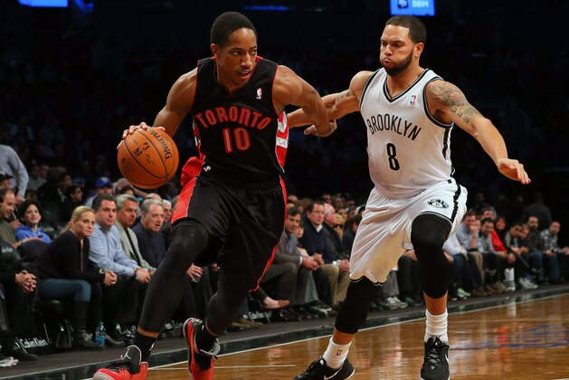 Mar 10, 2014; Brooklyn, NY, USA; Toronto Raptors shooting guard DeMar DeRozan (10) drives past Brooklyn Nets point guard Deron Williams (8) during the first quarter at the Barclays Center. Mandatory Credit: Adam Hunger-USA TODAY Sports