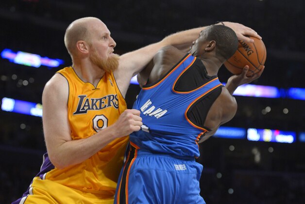 Los Angeles Lakers center Chris Kaman, left, fouls Oklahoma City Thunder power forward Serge Ibaka, of Congo, during the second half of an NBA basketball game, Thursday, Feb. 13, 2014, in Los Angeles. (AP Photo/Mark J. Terrill)