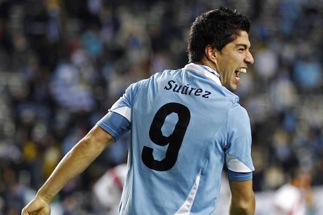 Uruguay's Luis Suarez celebrates after scoring his team's first goal during a Copa America semifinal soccer match against Peru in La Plata, Argentina, Tuesday, July 19, 2011. On top, an Uruguayan flag.  (AP Photo/Natacha Pisarenko)