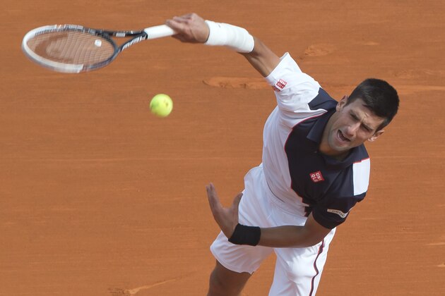 Novak Djokovic of Serbia serves the ball to Roger Federer of Switzerland during their semifinal match of the Monte Carlo Tennis Masters tournament in Monaco, Saturday, April 19, 2014. Federer won 7-6 6-2. (AP Photo/Michel Euler)