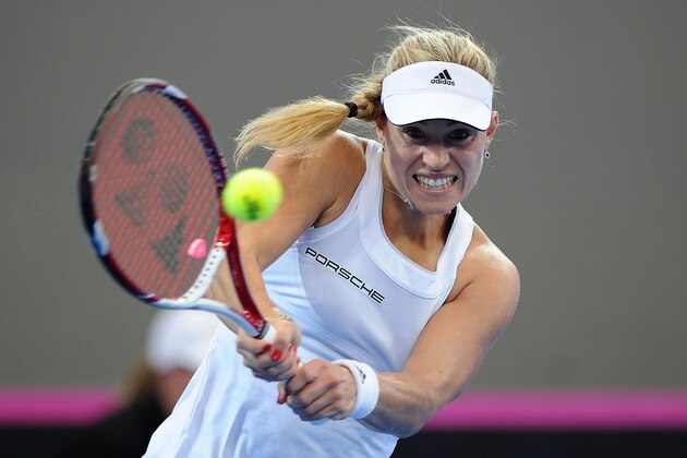 BRISBANE, AUSTRALIA - APRIL 19:  Angelique Kerber of Germany plays a backhand shot against Casey Dellacqua of Australia during the Fed Cup Semi Final tie between Australia and Germany at Pat Rafter Arena on April 19, 2014 in Brisbane, Australia.  (Photo by Matt Roberts/Getty Images)