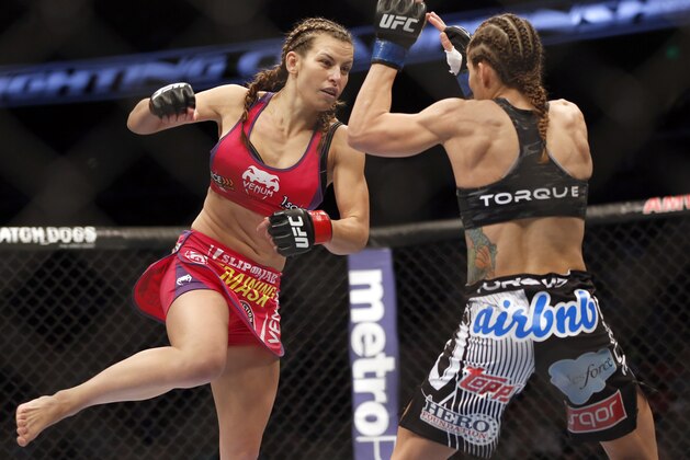Miesha Tate, left, and Liz Carmouche fight in a mixed martial arts event on Saturday, April 19, 2014, at UFC Fight Night in Orlando Fla. Tate defeated Carmouche. (AP Photo/Reinhold Matay)