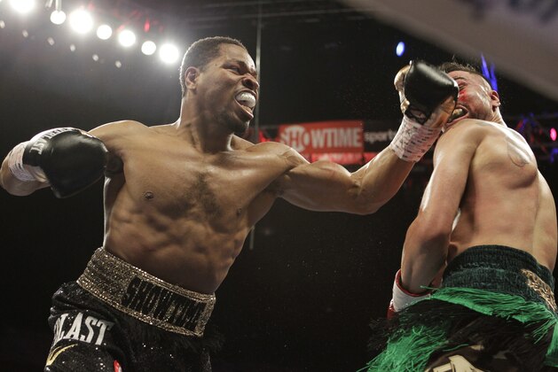 Shawn Porter, left, fights Paulie Malignaggi during the second round of their IBF Welterweight Champioship boxing match, Saturday, April 19, 2014, in Washington. Porter won with a TKO in the fourth round. (AP Photo/Luis M. Alvarez)
