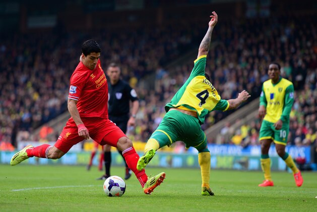 NORWICH, ENGLAND - APRIL 20:  Luis Suarez of Liverpool is challenged by Bradley Johnson of Norwich City during the Barclays Premier League match between Norwich City and Liverpool at Carrow Road on April 20, 2014 in Norwich, England.  (Photo by Jamie McDonald/Getty Images)