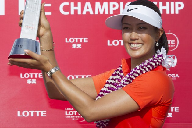 Michelle Wie holds up the 2014 LPGA LOTTE Championship trophy at Ko Olina Golf Club, Saturday, April 19, 2014, in Kapolei, Hawaii. (AP Photo/Eugene Tanner)