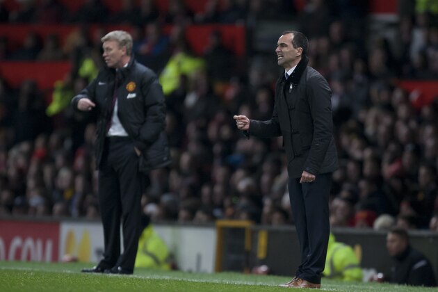 Everton's manager Roberto Martinez, right, issues instructions as he stands alongside Manchester United manager David Moyes during their English Premier League soccer match at Old Trafford Stadium, Manchester, England, Wednesday Dec. 4, 2013. (AP Photo/Jon Super)