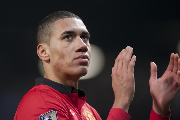 Manchester United's Chris Smalling applauds supporters after his team's 2-0 win against Swansea City in their English Premier League soccer match at Old Trafford Stadium, Manchester, England, Saturday Jan. 11, 2014. (AP Photo/Jon Super)