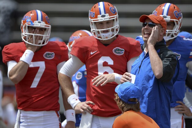 Florida's new Offensive Coordinator Kurt Roper, right, calls out instructions as he works with quarterbacks Will Grier (7) and Jeff Driskel (6) prior to the University of Florida's 2014 Orange & Blue Debut football game Saturday, April 12, 2014 in Gainesville, Fla.  (AP Photo/Phil Sandlin)