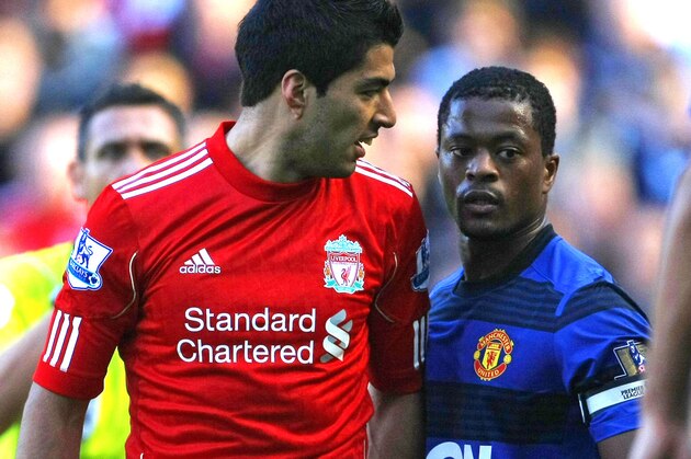 FILE - In this Oct. 15, 2011 file photo, Manchester United's Patrice Evra argues with Liverpool's Luis Suarez, left, during their English Premier League soccer match at Anfield, Liverpool, England.  The English Football Association said Tuesday, Dec. 20, 2011, that Liverpool striker Luis Suarez has been banned for eight matches and fined 40,000 pounds ($62,000) after being found guilty of racially abusing Manchester United defender Patrice Evra.  (AP Photo/Tim Hales, file)