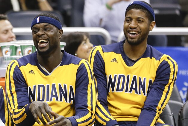 Indiana Pacers' Lance Stephensonl, left, and Paul George sit out a game against the Orlando Magic to rest for the playoffs at an NBA basketball game in Orlando, Fla., Wednesday, April 16, 2014. Indiana won 101-86. (AP Photo/John Raoux)