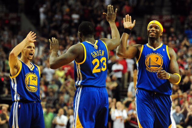 Golden State Warriors guard Stephen Curry (30) and Golden State Warriors center Jermaine O'Neal (7) celebrate after Golden State Warriors forward Draymond Green (23) hit a shot to tie the game at the end of the second half of an NBA basketball game in Portland, Ore., Sunday, April 13, 2014. The Blazers won the game 119-117. (AP Photo/Steve Dykes)