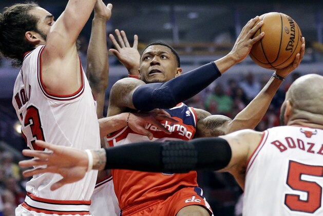 Washington Wizards guard Bradley Beal (3), center, drives to the basket against Chicago Bulls center Joakim Noah, left, and forward Carlos Boozer (5) during the first half in Game 1 of an opening-round NBA basketball playoff series in Chicago, Sunday, April 20, 2014. (AP Photo/Nam Y. Huh)