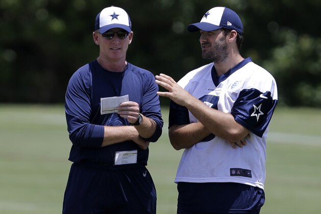 Dallas Cowboys head coach Jason Garrett, left, talks with quarterback Tony Romo as the two watch the team participate in drills during their NFL football minicamp on Tuesday, June 11, 2013, in Irving, Texas. (AP Photo/Tony Gutierrez)