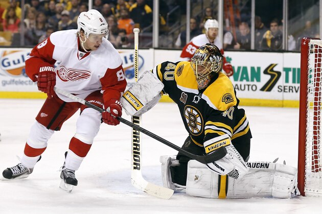 Boston Bruins goalie Tuukka Rask, right, makes a glove-save as Detroit Red Wings' Justin Abdelkader (8) looks for a rebound during the third period of Boston's 4-1 win in Game 2 of a first-round NHL hockey playoff series in Boston, Sunday, April 20, 2014. (AP Photo/Winslow Townson)