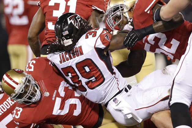 Atlanta Falcons running back Steven Jackson (39) is tackled by San Francisco 49ers linebacker NaVorro Bowman (53) and linebacker Patrick Willis (52) during the first quarter of an NFL football game in San Francisco, Monday, Dec. 23, 2013. (AP Photo/Marcio Jose Sanchez)