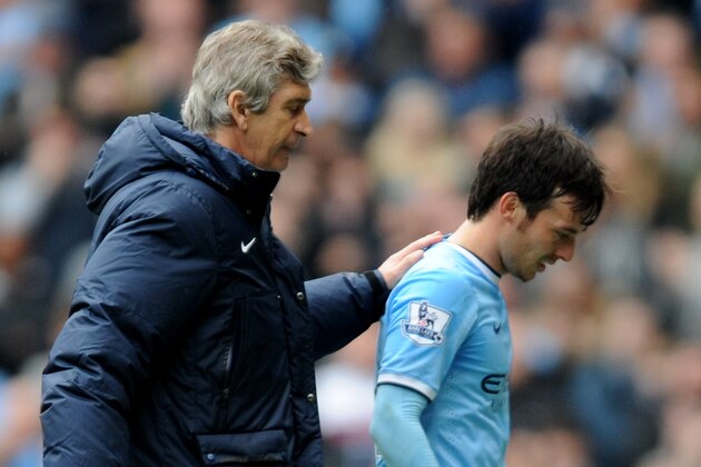 Manchester City manager Manuel Pellegrini, left, pats David Silva on the back after he is substituted  during the English Premier League soccer match between Manchester City and Southampton at The Etihad Stadium, Manchester, England, Saturday, April  5, 2014.  (AP Photo/Rui Vieira)