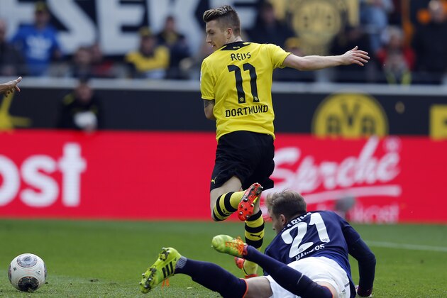 Dortmund's Marco Reus, rear, and Mainz goalkeeper Loris Karius challenge for the ball during the German first division Bundesliga soccer match between BvB Borussia Dortmund  and Mainz 05 in Dortmund, Germany, Saturday, April 19, 2014. (AP Photo/Frank Augstein)